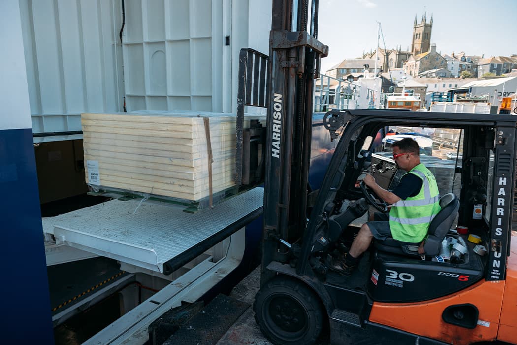Forklift truck loading a pallet onto Menawethan in Penzance