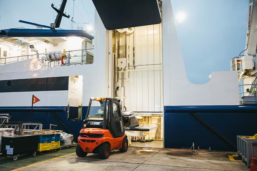 Forklift truck unloading freight ship Menawethan on St Mary's Quay