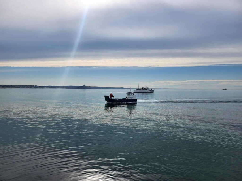 Gugh landing craft sailing past Scillonian III in Penzance