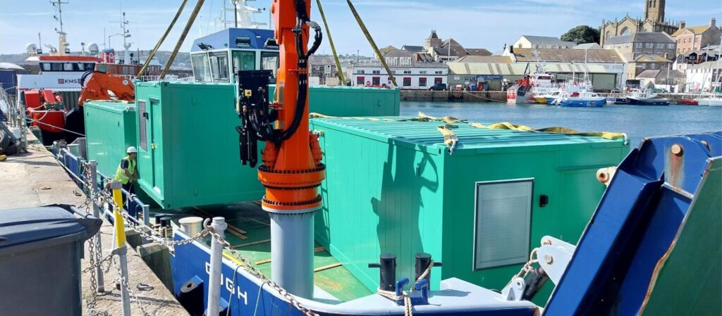 Gugh being loaded with green modular cabins in penzance - Isles of Scilly Freight