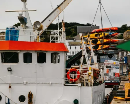 Kayaks being craned onto Gry Maritha from St Mary's Quay