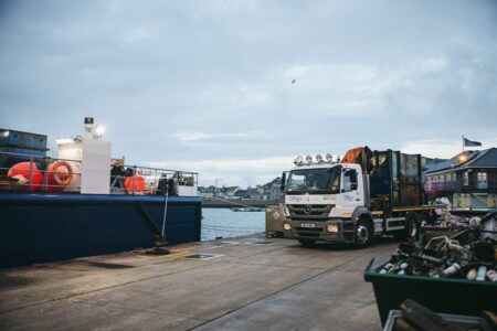 Island Carrier lorry delivering waste container to St Mary's Quay